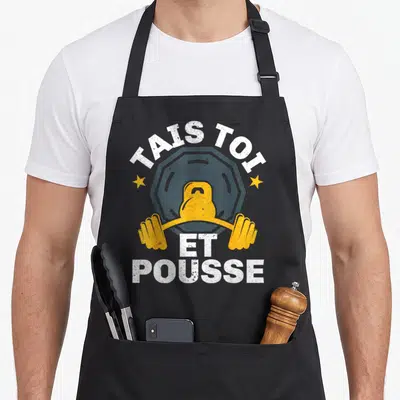 Tablier de cuisine noir avec illustration kettlebell jaune et texte blanc Tais Toi Et Pousse.
