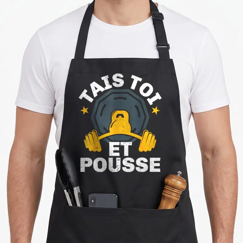 Tablier de cuisine noir avec illustration kettlebell jaune et texte blanc Tais Toi Et Pousse.