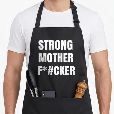 Tablier de cuisine noir avec inscription blanche Strong Mother F*#cker en lettres capitales stylisées.