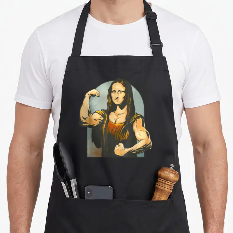 Tablier de cuisine noir avec une illustration de La Joconde musclée flexant ses biceps dans un cadre en arc de cercle.