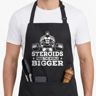 Tablier de cuisine noir avec un bodybuilder soulevant une barre et le texte Steroids Make The World Bigger en blanc.