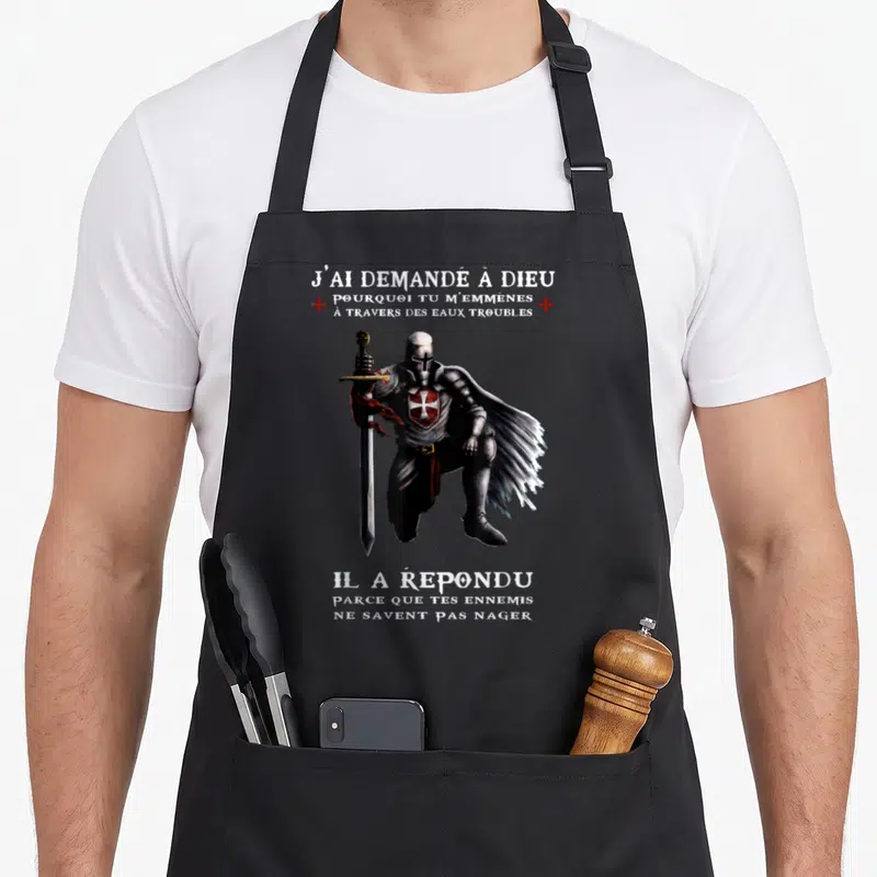 Tablier de cuisine noir avec illustration d'un chevalier templier tenant une épée et texte humoristique en blanc et rouge.