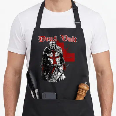Tablier de cuisine noir avec illustration d'un chevalier templier et texte Deus Vult en lettres gothiques rouges.