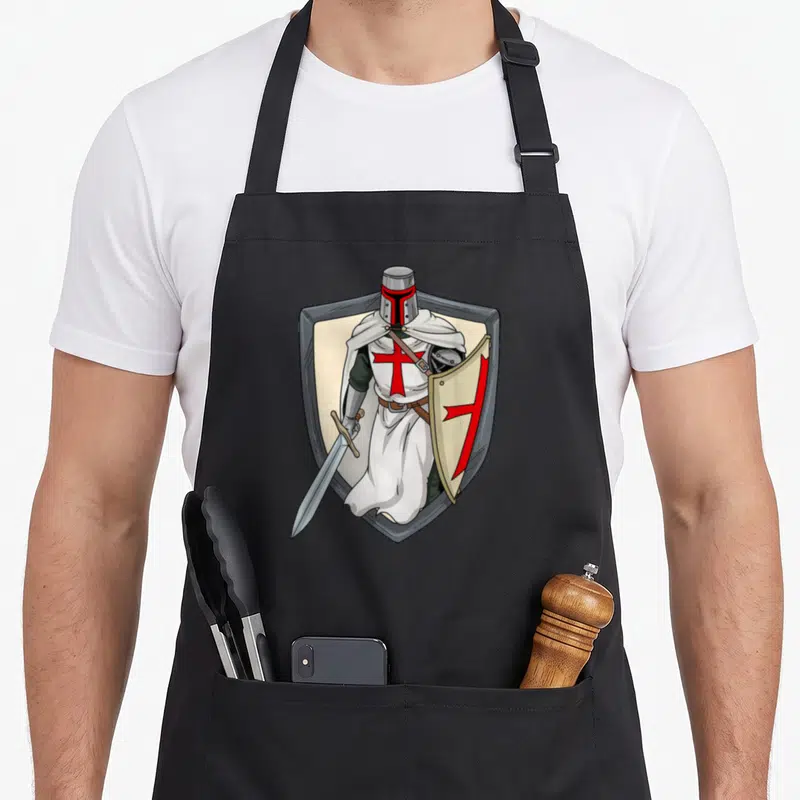 Tablier de cuisine noir avec illustration d'un chevalier templier tenant une épée et un bouclier à croix rouge.