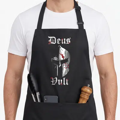 Tablier de cuisine noir avec casque de croisé blanc taché de rouge et texte gothique Deus Vult.