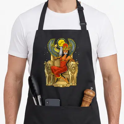 Tablier de cuisine noir avec illustration colorée de la déesse Sekhmet assise entre deux lions et un oiseau aux ailes déployées.