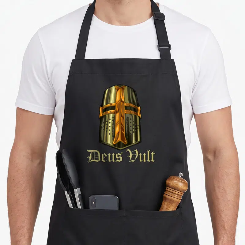 Tablier de cuisine noir avec illustration de casque de Templier et texte Deus Vult en typographie gothique.