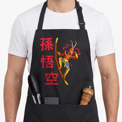 Tablier de cuisine noir avec illustration colorée de Sun Wukong tenant une baguette et des symboles chinois rouges.