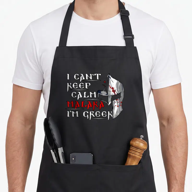 Tablier de cuisine noir avec inscription I Can't Keep Calm Malaka I'm Greek et illustration de casque corinthien.