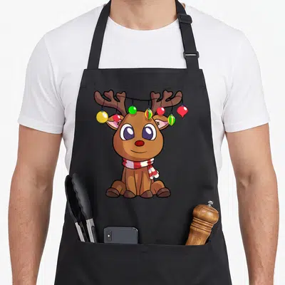 Tablier de cuisine noir avec un renne cartoon aux bois ornés de guirlandes multicolores et d'une écharpe rouge et blanche.