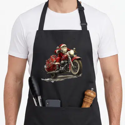Tablier de cuisine noir avec illustration d'un Père Noël en costume rouge montant une moto vintage rouge transportant des paquets cadeaux.