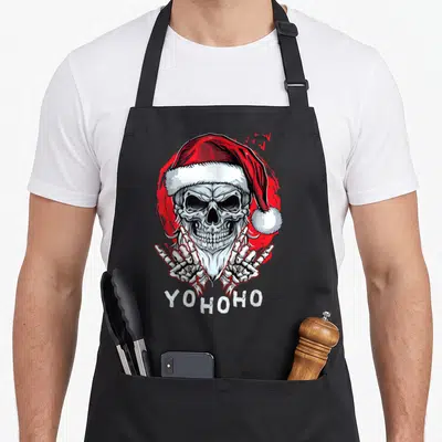 Tablier de cuisine noir avec un crâne portant une casquette de Noël et le texte Yohocho en blanc.