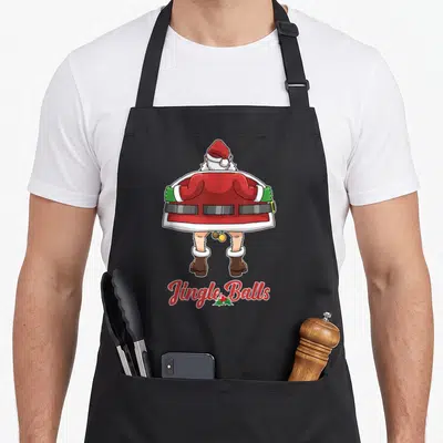 Tablier de cuisine noir avec illustration du dos du Père Noël et texte Jingle Balls en bas.