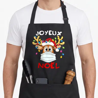 Tablier de cuisine noir avec illustration d'un renne au masque blanc, chapeau de Père Noël et guirlande lumineuse multicolore.