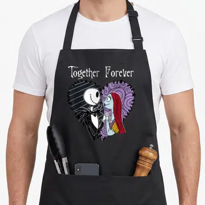 Tablier de cuisine noir avec Jack et Sally dans un cœur cousu et l'inscription Together Forever.