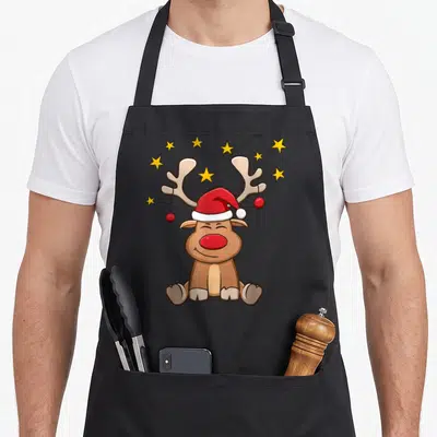 Tablier de cuisine noir avec illustration d'un ren Rudolf portant un chapeau de Père Noël et des étoiles jaunes.
