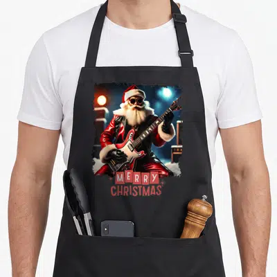 Tablier de cuisine noir avec un Père Noël rockeur jouant d'une guitare rouge et le texte Merry Christmas en bas.
