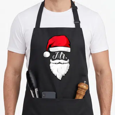 Tablier de cuisine noir avec illustration de bonnet rouge, barbe blanche et texte Mr en calligraphie.