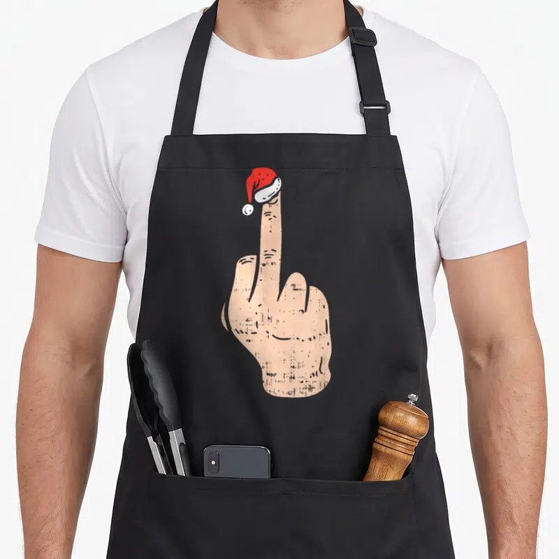 Tablier de cuisine noir avec illustration d'une main faisant un geste d'offense portant un chapeau de Père Noël rouge et blanc.