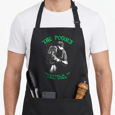 Tablier de cuisine noir avec illustration couple s'enlacant et texte vert The Pogues Fairytale of New York.