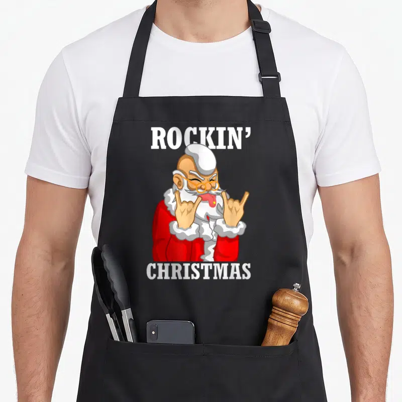 Tablier de cuisine noir avec illustration d'un Père Noël rock effectuant le signe des cornes en rouge et blanc.
