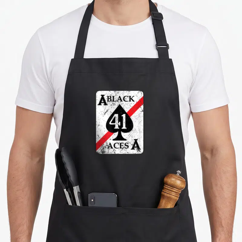 Tablier de cuisine noir avec un motif rectangulaire blanc portant la mention Black Aces 41 et une grande pique noire traversée par une bande rouge.