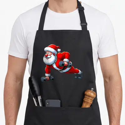 Tablier de cuisine noir avec illustration du Père Noël en planche tenant des dumbbells rouges et blancs.
