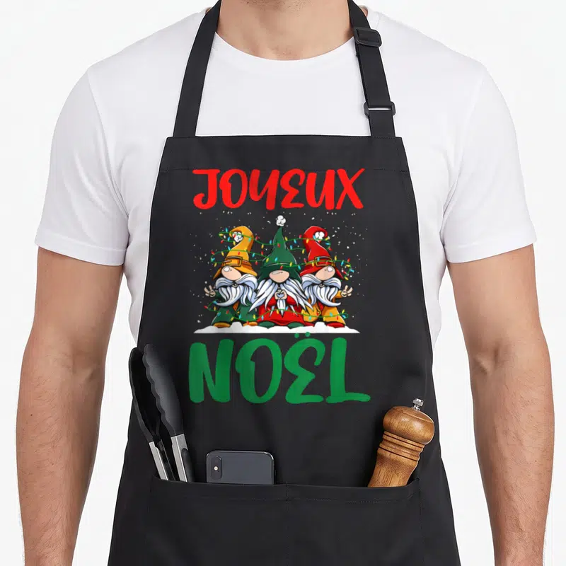 Tablier de cuisine noir avec trois gnomes de Noël entrelacés par des guirlandes lumineuses multicolores.