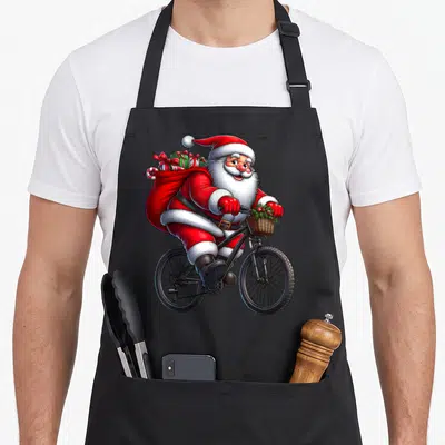 Tablier de cuisine noir avec illustration colorée d'un Père Noël sur vélo chargé de cadeaux dans un sac rouge.