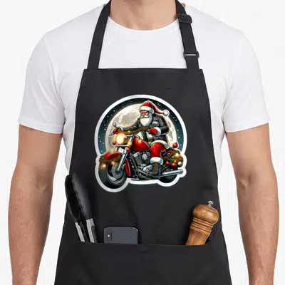 Tablier de cuisine noir avec illustration d'un Père Noël en costume de motard sur une moto rouge ornée de guirlandes.