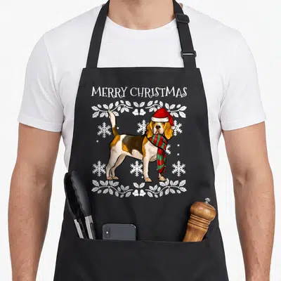 Tablier de cuisine noir avec illustration d'un beagle en tenue de Noël entouré de motifs hivernaux blancs.