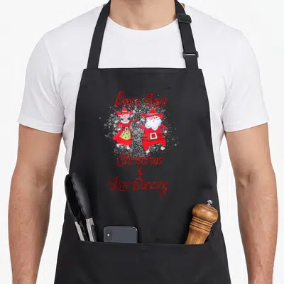 Tablier de cuisine noir avec Santa et femme en line dance et texte Peace Love Christmas Line Dancing en rouge.