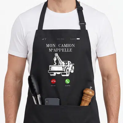 Tablier de cuisine noir avec illustration blanche de remorqueur et texte Mon camion m'appelle au centre.