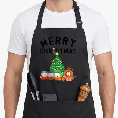 Tablier de cuisine noir avec illustration Merry Christmas et quatre personnages de dessin animé devant un sapin de Noël coloré.