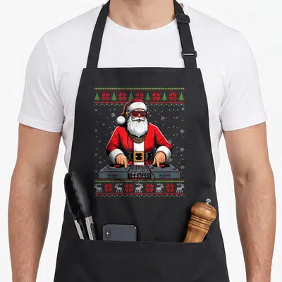 Tablier de cuisine noir avec illustration d'un Père Noël DJ portant des lunettes de soleil et des écouteurs devant un mixeur.