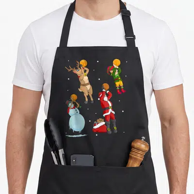 Tablier de cuisine noir avec Santa, renne, elfe et bonhomme de neige jouant au basket-ball.