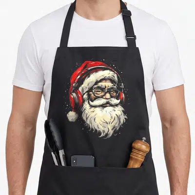 Tablier de cuisine noir avec illustration d'un Père Noël portant un casque audio rouge et des lunettes.