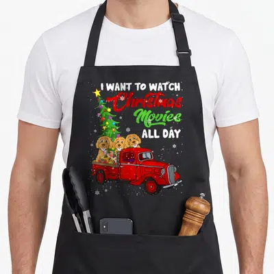 Tablier de cuisine noir avec trois cockapoos dans un camion rouge devant un sapin de Noël.