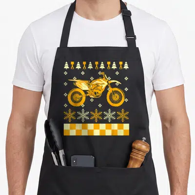 Tablier de cuisine noir avec moto dirt bike orange, flocons et damier de course imprimés.