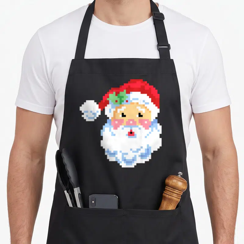 Tablier de cuisine noir avec illustration Santa Claus pixel art rouge et blanc style jeu vidéo rétro.