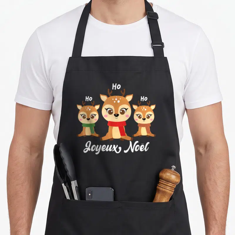 Tablier de cuisine noir avec trois rennes dessinés et l'inscription Joyeux Noël en blanc.