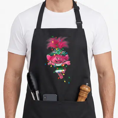 Tablier de cuisine noir avec Poppy des Trolls rose enchaînée à des guirlandes lumineuses multicolores.