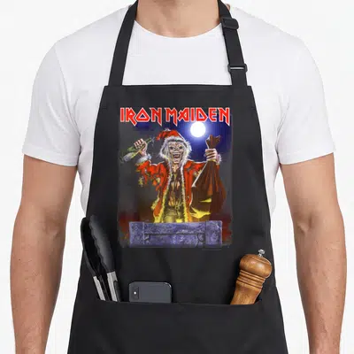Tablier de cuisine noir avec Eddie en Père Noël tenant une bouteille et un sac sombre.
