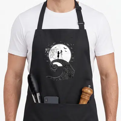 Tablier de cuisine noir avec silhouette de couple sous lune et inscription Meant to Be sur d'une ondulante.