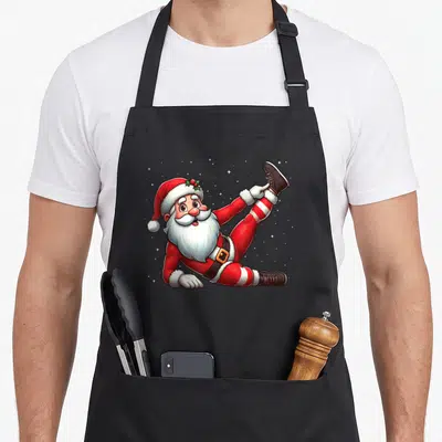 Tablier de cuisine noir avec illustration d'un Père Noël s'étirant les jambes en tenue de sport sous la neige.