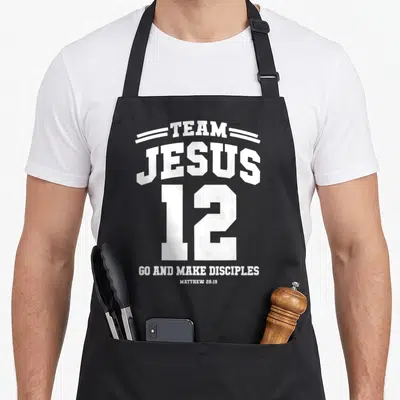 Tablier de cuisine noir avec inscription blanche Team Jesus 12 et citation biblique en typographie sportive.