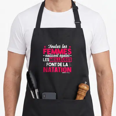 Tablier de cuisine noir avec inscription rose et blanche sur le thème de la natation et des femmes.