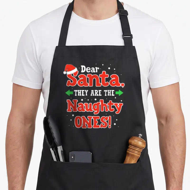 Tablier de cuisine noir avec le texte Dear Santa They Are The Naughty Ones en rouge et blanc.