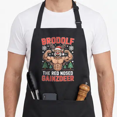 Tablier de cuisine noir avec illustration d'un renne musclé portant un bonnet de Père Noël et le texte Brodolf.
