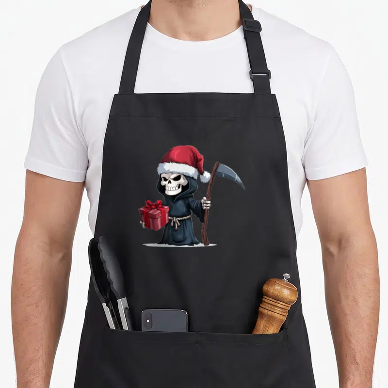 Tablier de cuisine noir avec une faucheuse en costume de Noël tenant un cadeau et une faux.